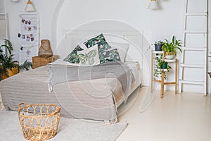 Cozy rustic bedroom with boho ethnic decor.Plants in the interior.