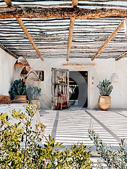 Cozy rustic patio with potted plants and rattan lamps