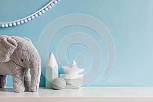 Cozy scandinavian newborn baby room with gray plush elephant, white stars lamp and children accessories.