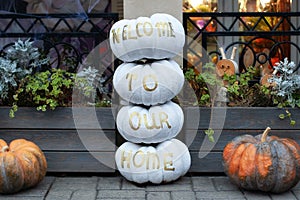 Cozy scary porch of the house with orange and white pumpkins in fall time. Halloween design home. Street decoration thanksgiving.