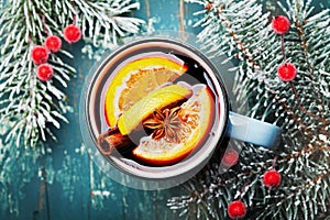 Cozy shot of christmas mulled wine or gluhwein with spices and orange slices on teal table top view. Traditional drink on winter.