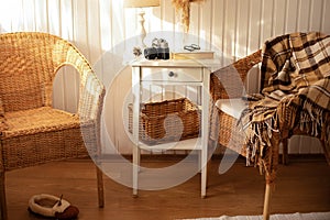 Cozy Skandinavian interior home with wicker rattan armchairs in living room. Rattan chair and wooden table in bedroom. Rustic inte photo