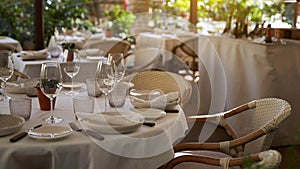 Cozy Spanish outdoor restaurant. Beautiful served tables and wicker chairs on a sunny evening in Iberian style.