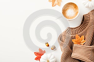 Cozy still life with knitted sweater, coffee mug, decorative pumpkins, maple leaves. Top view. Flat lay