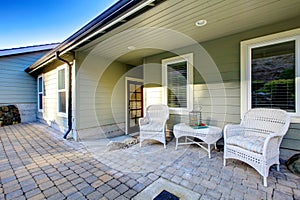 Cozy stoned porch with a wicker pation table set photo