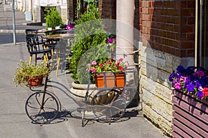 Cozy street cafe in city, beautifully decorated with flowers and bike