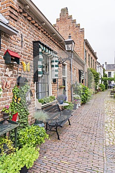 A cozy street full of flowers and plants in the old fortress town of Buren, the Netherlands photo