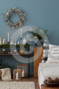 Cozy and stylish christmas living room interior with, modular sofa, wooden console with spruce, balls, candlestick with candle,