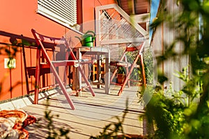 Cozy summer balcony: Red chairs, sunshine, nobody