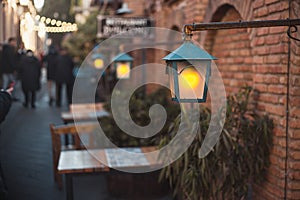 Cozy tables of street cafe with lanterns and warm light