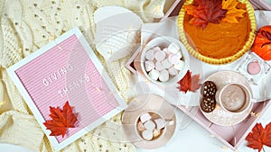 Cozy Thanksgiving flatlay overhead with pumpkin pie and hot chocolate.