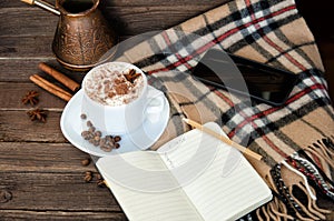 Cozy vacation. Latte mug, notebook, pencil, smart phone, plaid and cezve