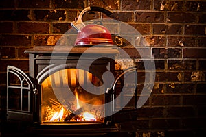 Cozy, warm fire heating a kettle against a brick hearth