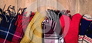 Cozy winter background Warm knitted scarfs and mittens on wooden background with space for text Top view. Copy space Long Toned