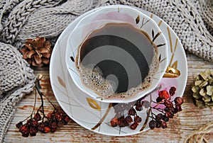 Cozy winter coffee. Porcelain cup with black coffee on a background of old wooden boards.
