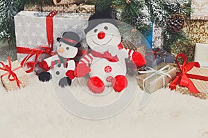 Cozy christmas background. Toy snowmen and presents under new ye