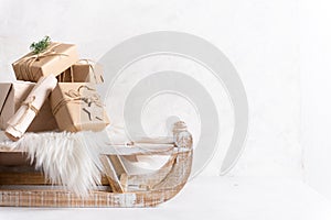 Cozy winter holidays. Christmas gifts on the sledge on white background. Hygge, greeting card. Copy space