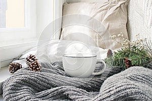 Cozy winter morning breakfast in bed still life scene. Steaming cup of hot coffee, tea standing near window. Christmas