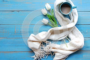 Cozy winter relax time.  Cup of hot coffee with lily flower on the blue wood background in morning sunny