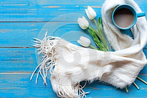 Cozy winter relax time.  Cup of hot coffee with white lily flower on the blue wood background