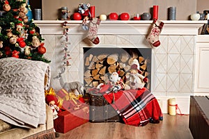 Cozyness and home comfort. Decorated fireplace with firewood. Winter holidays room interior, Christmas atmosphere.