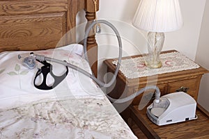 CPAP Sleep Apnea Machine Lying on Bed in Bedroom