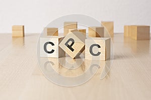 CPC - an abbreviation of wooden blocks with letters on a gray background. reflection caption on the mirrored surface of