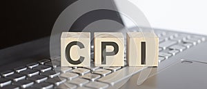 CPI abbreviation written on a wooden cube on laptop