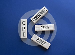 CPI - Consumer Price Index symbol. Concept word CPI on wooden blocks. Beautiful deep blue background. Business and CPI concept.
