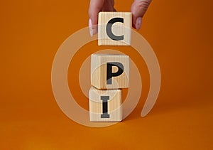 CPI - Consumer Price Index symbol. Concept word CPI on wooden cubes. Businessman hand. Beautiful grey background. Business and CPI