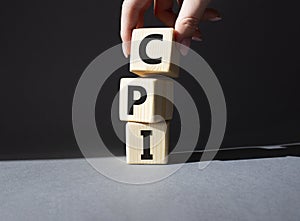 CPI - Consumer Price Index symbol. Concept word CPI on wooden cubes. Businessman hand. Beautiful grey background. Business and CPI