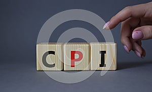 CPI - Consumer Price Index symbol. Concept word CPI on wooden cubes. Businessman hand. Beautiful grey background. Business and CPI