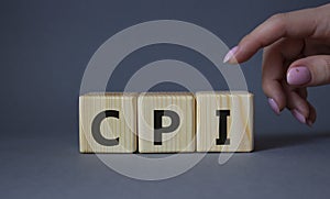 CPI - Consumer Price Index symbol. Concept word CPI on wooden cubes. Businessman hand. Beautiful grey background. Business and CPI