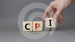 CPI - Consumer Price Index symbol. Concept word CPI on wooden cubes. Businessman hand. Beautiful grey background. Business and CPI