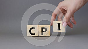 CPI - Consumer Price Index symbol. Concept word CPI on wooden cubes. Businessman hand. Beautiful grey background. Business and CPI