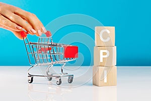 CPI - Consumer Price Index symbol.Letter block in word CPI abbreviation of consumer price index and woman`s hand pushing empty