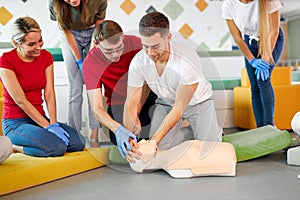 CPR class with caucasian instructors speaking and demonstrating help first aid