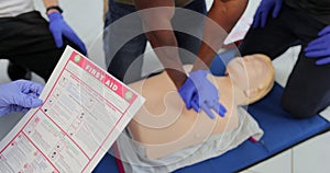 CPR First Aid training concept. Back view of woman holding first aid instruction during cpr training class.