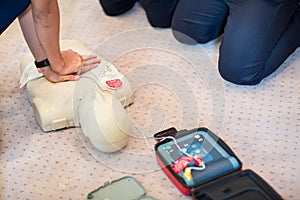 CPR training using and an AED and bag mask valve on an adult training manikin.