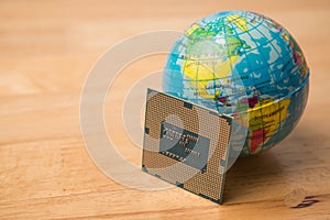 CPU (central processing unit) computer, globe on wooden table background. photo
