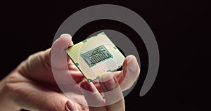 CPU in hands of a technician. The processor is being examined for apparent defects. In Modern Electronic Manufacturing