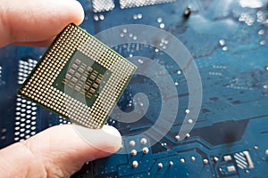 CPU processor in woman hand against computer motherboard