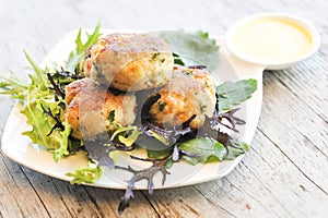 Crab cakes with sauce on rustic table