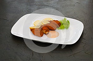 Crab claws fried in batter with lemon, lettuce and sauce