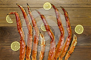 Crab claws with lemon on wooden background