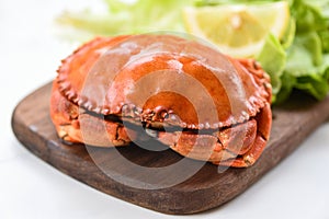 Crab cooked steam or boiled with lemon and lettuce salad vegetable on wooden board in a restaurant - Fresh seafood stone crab