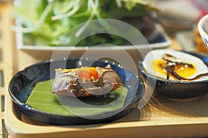 Crab eggs in Crab shell on banana leaf with half boiled egg on a table