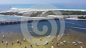 Crab Island with dense of tourist boats, yachts near Destin Bridge or William T. Marler Bridge, overlooking white sandy Eglin