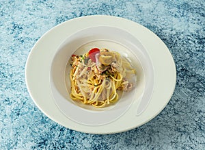 crab meat aglio olio with cherry tomato and lemon served in plate isolated on background top view of italian food