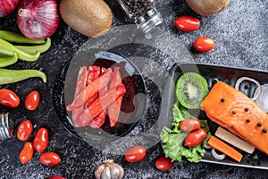 Crab stick put on a black plate on the black cement floor